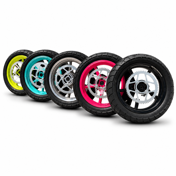 Five small off-road wheels with black knobby tires and colorful rims, arranged in a diagonal row on a white background. The rim colors are yellow, teal, silver, hot pink, and black.