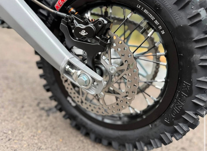 Close-up of a motorcycle wheel with tire and suspension details.