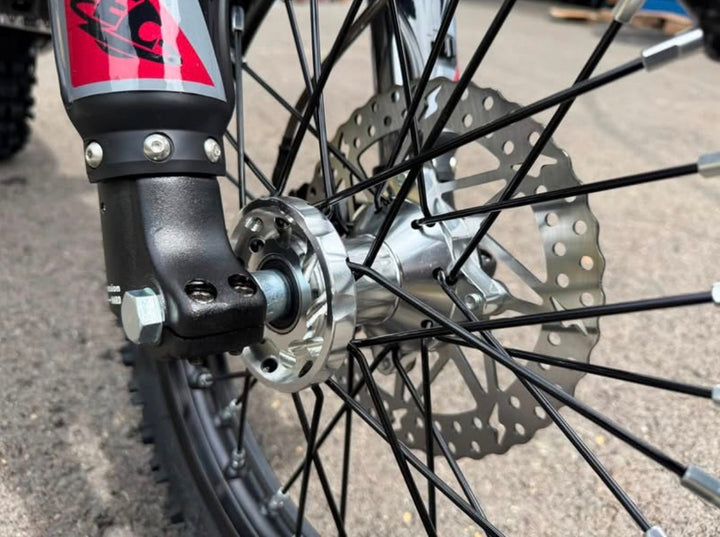Close-up of a bicycle wheel with disc brake and suspension fork
