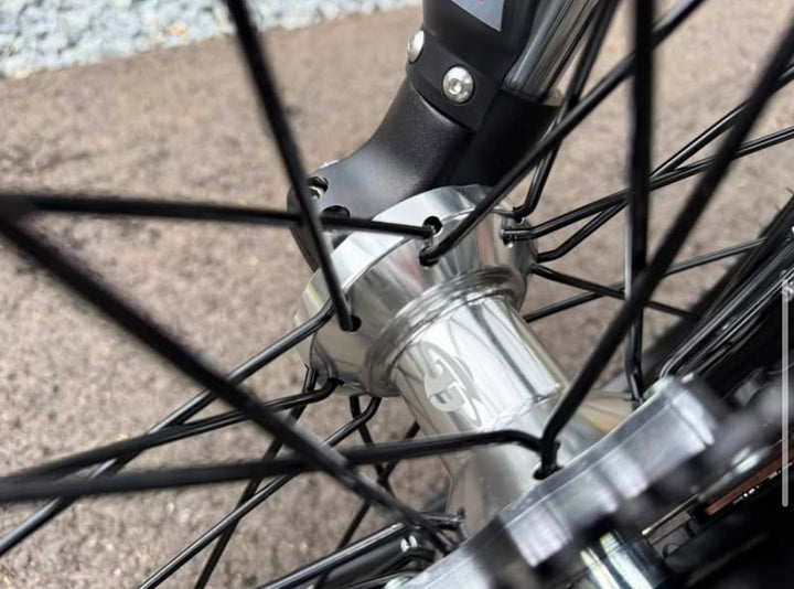 Close-up of a bicycle hub with visible brand name on a concrete surface