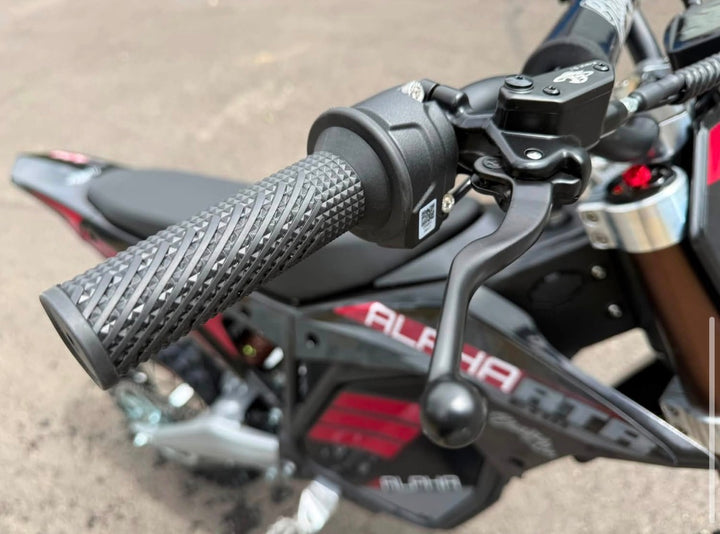 Close-up of motorcycle handlebar with 'Alpha' branding on a blurred background