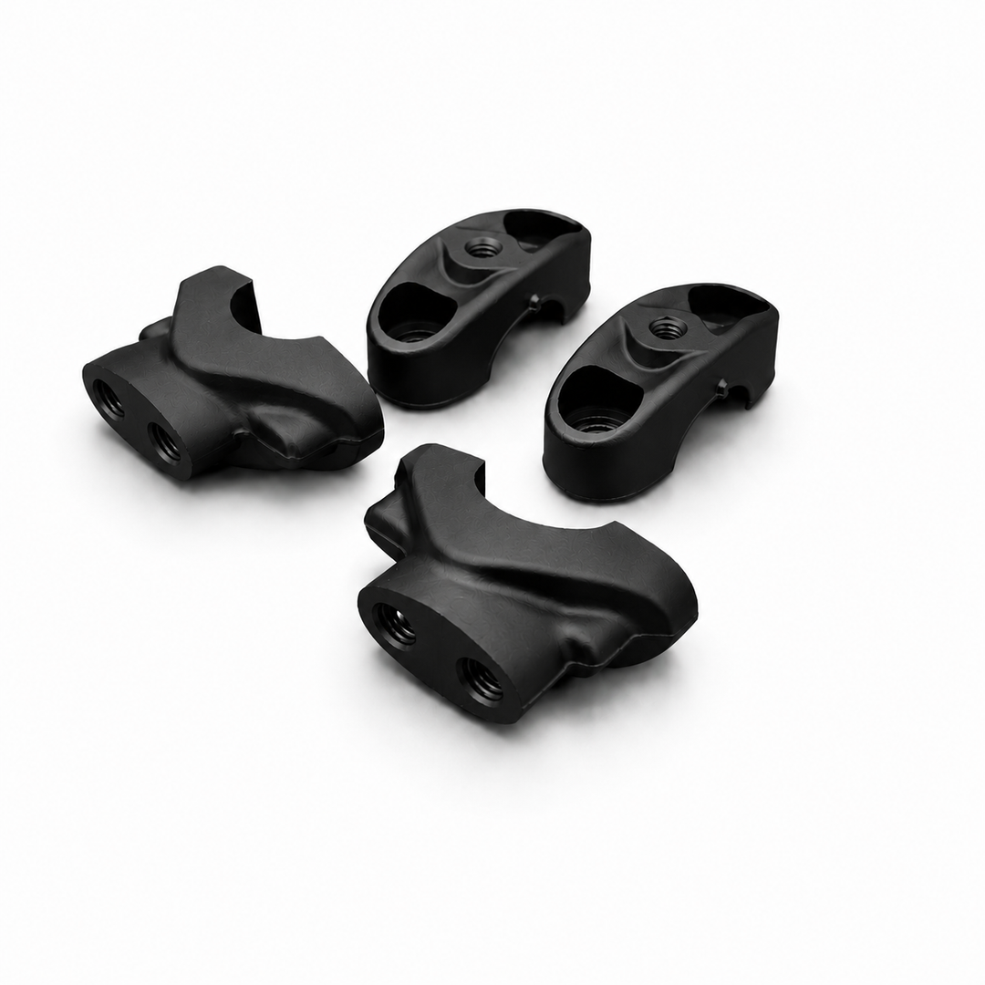 Four black plastic components on a white background