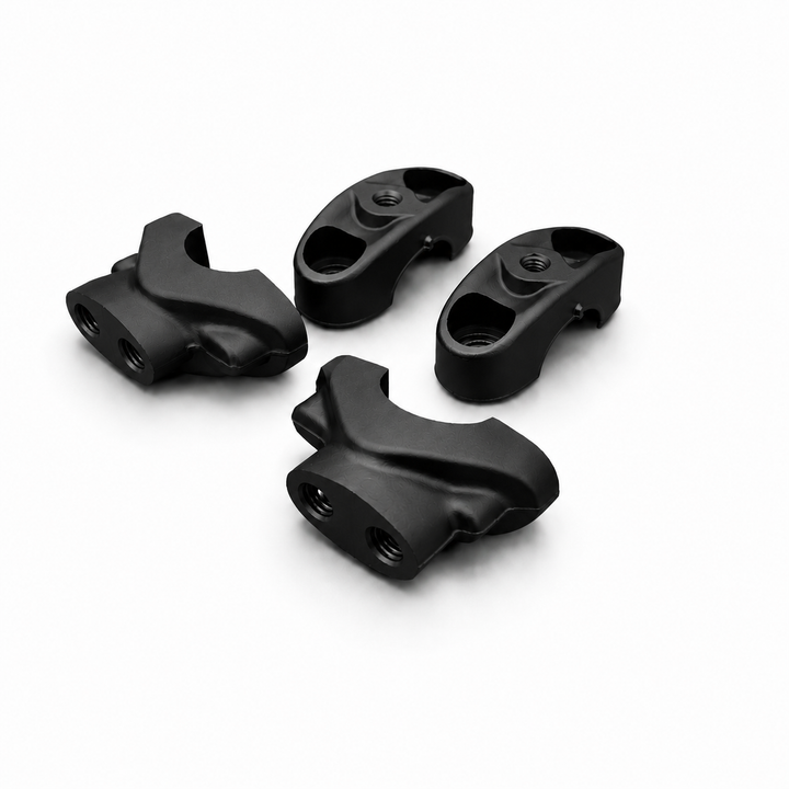 Four black plastic components on a white background