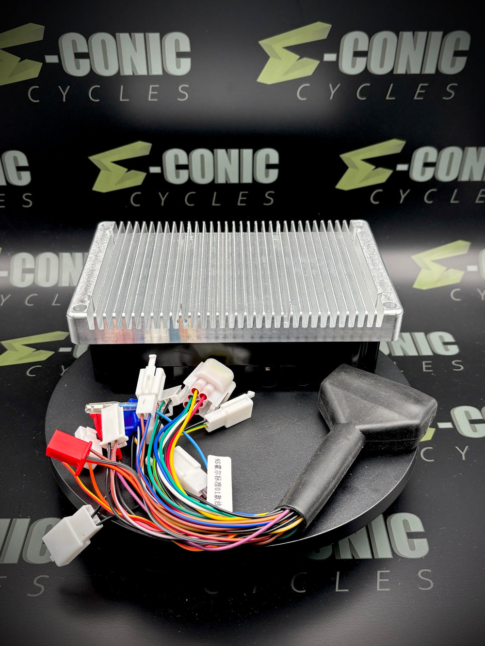 Electronic components with wiring on a black surface, branded 'e-Conic Cycles'.