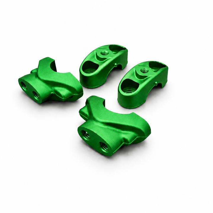 Four green metal mechanical parts on a white background