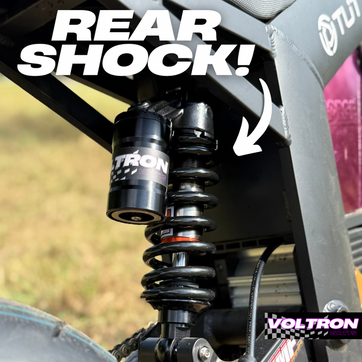Close-up of a VOLTRON rear shock on a vehicle with text highlighting the component.